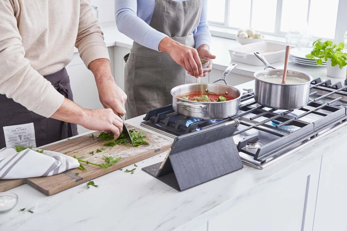 Two people preparing food together in a home kitchen